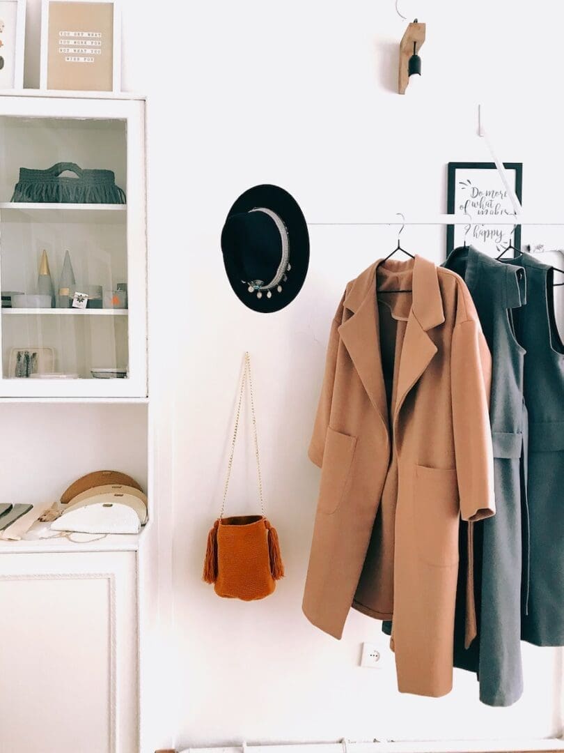 brown coat hanging beside the crossbody bag